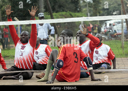 Kampala, Uganda. 23. Oktober 2014. Menschen mit Behinderungen nehmen Sie sich Zeit, spielen Volleyball während der nationalen Behinderten Sport-Gala in Kampala, Uganda Kredit sitzen: Samson Opus/Alamy Live News Stockfoto