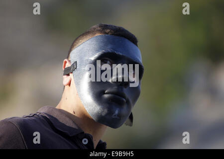 Jerusalem, Palästina. 23. Oktober 2014. Eine maskierte palästinensische Jugend blickt auf bei Zusammenstößen mit der israelischen Polizei im Stadtteil East Jerusalem von Issawija 23. Oktober 2014. Spannung in Jerusalem stieg am Mittwoch nach eine israelischen Baby starb und acht weitere Menschen verletzt, wurden wenn ein palästinensischer Mann sein Auto in Fußgänger an einer Jerusalem-Stadtbahn-Haltestelle schlug. Polizei erschossen den Fahrer flüchtete. Ein Krankenhaus-Beamter sagte der Fahrer starb später an seinen Verletzungen Credit: Muammar Awad/APA Bilder/ZUMA Draht/Alamy Live News Stockfoto