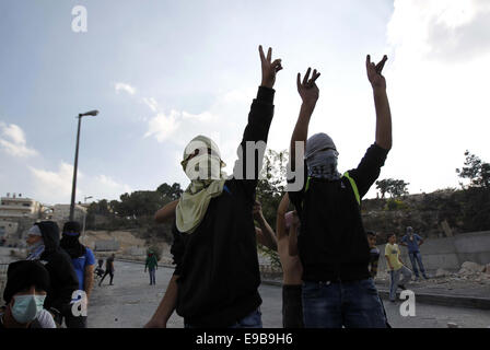 Jerusalem, Palästina. 23. Oktober 2014. Palästinensische Jugendliche Geste bei Zusammenstößen mit der israelischen Polizei im Stadtteil East Jerusalem von Issawija 23. Oktober 2014. Spannung in Jerusalem stieg am Mittwoch nach eine israelischen Baby starb und acht weitere Menschen verletzt, wurden wenn ein palästinensischer Mann sein Auto in Fußgänger an einer Jerusalem-Stadtbahn-Haltestelle schlug. Polizei erschossen den Fahrer flüchtete. Ein Krankenhaus-Beamter sagte der Fahrer starb später an seinen Verletzungen Credit: Muammar Awad/APA Bilder/ZUMA Draht/Alamy Live News Stockfoto