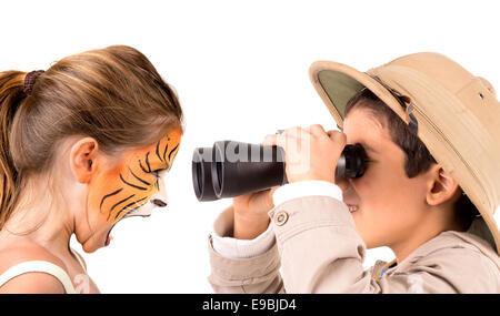 Schöne junge Mädchen mit Gesicht gemalt wie ein Tiger und junge Forscher mit dem Fernglas Stockfoto