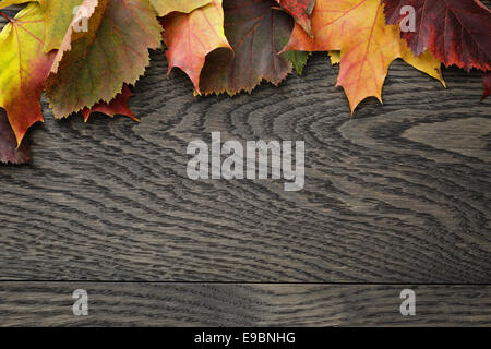 Herbstlaub auf alten Eichentisch direkt von oben Stockfoto