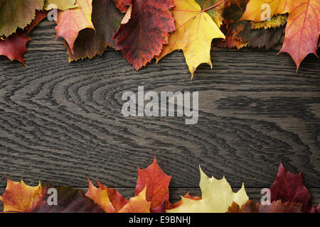 Herbstlaub auf alten Eichentisch direkt von oben Stockfoto