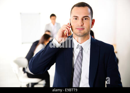 Unternehmer, die auf dem Smartphone vor Business-Meeting im Gespräch Stockfoto