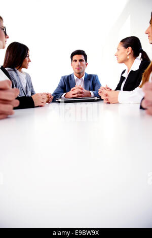 Geschäftsleute, die auf einer Sitzung am Tisch sitzen Stockfoto