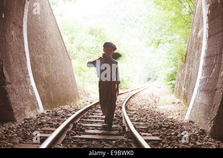 Kind zu Fuß mit Vintage Siutcase Eisenbahn unterwegs. Stockfoto