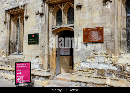 Eingangstür im York Minster Shop in zentralen York, UK. Rechts der Tür befindet sich eine Gedenktafel für Miles Coverdale. Stockfoto