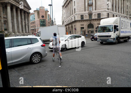 Eine Stadt von London gefährliche Radfahrer Kurier über seinen Weg durch viel Verkehr Pkw und Lkw Staus in der Nähe von Lombard Street Junction in der Londoner City zu drücken. KATHY DEWITT Stockfoto