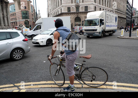 Eine Stadt von London Radfahrer courier Vorbereitung eine gefährliche Bewegung über seinen Weg durch die langen Staus in der Innenstadt von London zu drücken. KATHY DEWITT Stockfoto