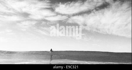 Surfer am Anfang eine große Welle in schwarz / weiß Stockfoto