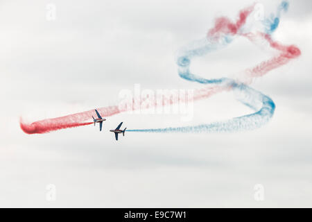 Zwei Mitglieder der französischen Luftwaffe Kunstflug Display Team La Patrouille de France in ihren Alpha Jets ausführen Cross-overs Stockfoto