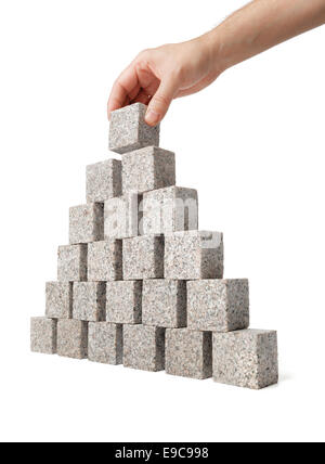 Menschen bauen Pyramide aus kleinen Blöcken von Granitfelsen. Stockfoto