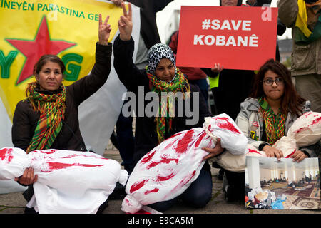 Kopenhagen, Dänemark. 24. Oktober 2014. Tote Kinder – den höchsten Preis des Krieges in Kobani, Syrien. Kurdische Frauen, Teilnahme an einer Demonstration der Solidarität am Bundesplatz in Kopenhagen, mit Blut befleckt Leichensäcke als Symbol für die Schrecken der kriegszerstörten Stadt Credit: OJPHOTOS/Alamy Live News Stockfoto