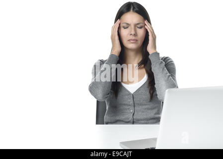 Junge Frau leidet unter Kopfschmerzen oder Migräne mit Blick auf Laptop auf dem Tisch. isoliert auf weißem Hintergrund Stockfoto