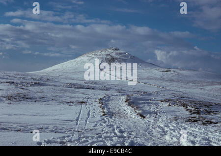 Shutlingsloe Hügel bedeckt mit Schnee in der Nähe von Wildboarclough Macclesfield im Peak District.  Es ist eine Strecke im Vordergrund. Stockfoto