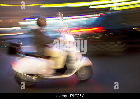 Abstraktes Bild verschwommen einen Roller fahren bei Nacht. Stockfoto