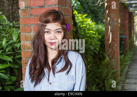 Pinoy Frau in einem grünen Garten auf Hof, gemauerte Säule gelehnt Stockfoto