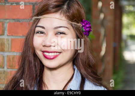 Pinoy Frau in einem grünen Garten auf Hof, gemauerte Säule gelehnt Stockfoto