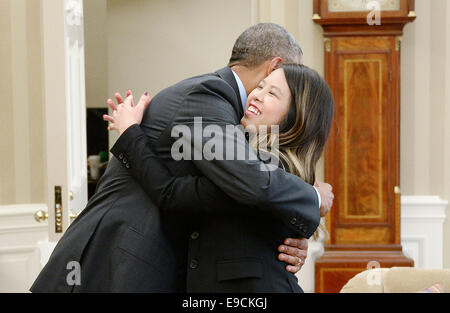 Washington, DC. 24. Oktober 2014. US-Präsident Barack Obama gibt eine Umarmung zu Nina Pham aus Dallas, Texas, die erste Krankenschwester in den Vereinigten Staaten diagnostiziert mit Ebola im Oval Office des weißen Hauses 24. Oktober 2014 in Washington, DC. Pham wurde früher in den Tag "frei von Ebola" auf einer Pressekonferenz an die National Institutes of Health erklärt. Bildnachweis: Olivier Douliery/Pool über CNP - NO WIRE SERVICE - Credit: Dpa/Alamy Live-Nachrichten Stockfoto