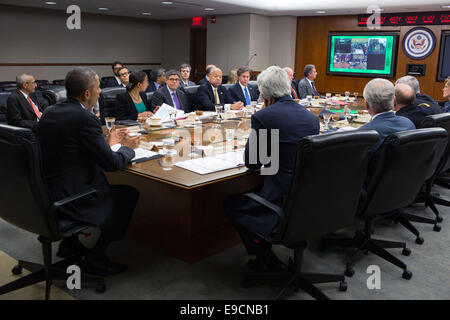 US-Präsident Barack Obama, beteiligt sich mit Außenminister John Kerry und andere Mitglieder des Kabinetts, in einer sicheren video Telekonferenz mit der US-Botschaft Bagdad und Generalkonsulate in Erbil und Basrah, an das Department of State 24. Oktober 2014 in Washington, DC. Stockfoto