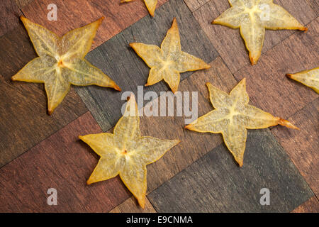 Carambola - Sternfrucht Scheiben auf hölzernen Hintergrund Stockfoto