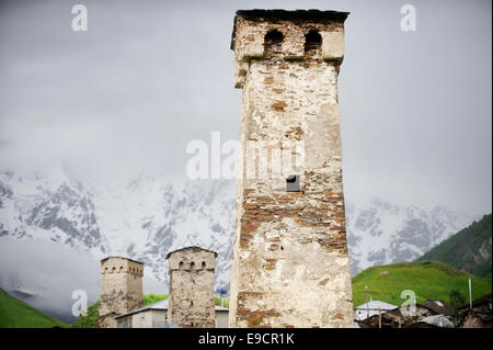 Ushguli Svan Türme mit Shkhara Berg bedeckt mit Schnee und Nebel im Hintergrund Stockfoto