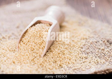 Haufen von Couscous (Nahaufnahme) auf dunklem Holz Stockfoto
