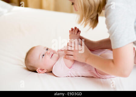 Mutter massieren oder machen Gymnastik Babymädchen Stockfoto