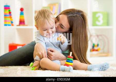 glückliche Mutter und Kind Sohn zu Hause drinnen spielen