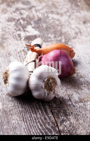 Nahaufnahme von Knoblauch und Zwiebeln auf einem Holzbrett Stockfoto