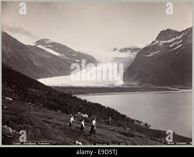 Foto von Nordlands Svartisen-Gletscher, aufgenommen von Axel Lindahl. Das Bild zeigt die massive Eisstruktur des Gletschers vor dem ländlichen Hintergrund von Ackerland. Dieses Foto bietet einen Einblick in die Landwirtschaft und Gletscherlandschaft von Nordland, Norwegen. Stockfoto