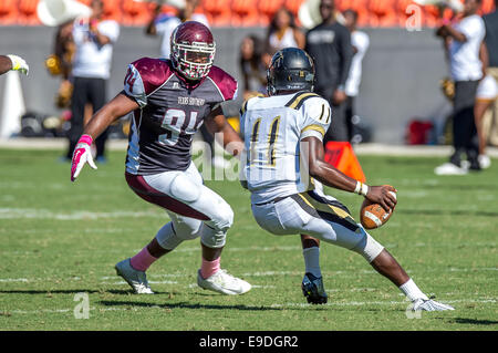 25. Oktober 2014 - Houston, Texas, USA: Arkansas-Pine Bluff Golden Lions Quarterback Benjamin Anderson (11) durch Texas Southern Tigers defensive Lineman Derrick Lyles (94) während der NCAA Football-Spiel zwischen der University of Arkansas in Pine Bluff Golden Lions und die Texas Southern Tigers BBVA Compass Stadium, Houston, Tx. Arkansas verfolgt-Pine Bluff schlagen TSU 38-37 Stockfoto