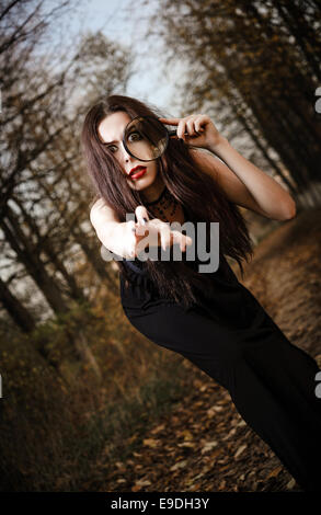 Ein seltsames Goth-Mädchen hält aussehende Glas in der hand Stockfoto