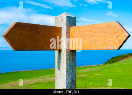 Leere Wegweiser aus Holz mit zwei Pfeilen über strahlend blauen Himmel mit Textfreiraum Stockfoto