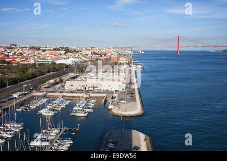 Stadt von Lissabon in Portugal, Doca de Belem Marina, Tagus Fluss Kai und 25 de Abril Brücke am anderen Ende. Stockfoto