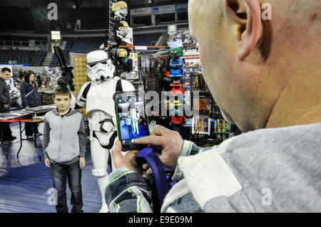 Belfast, Nordirland. 26. Oktober 2014 - ein Mann nimmt ein Foto seines Sohnes mit einer Stormtrooper mit Hilfe eines Mobiltelefons an Film- und Comicon 2014 Credit: Stephen Barnes/Alamy Live News Stockfoto
