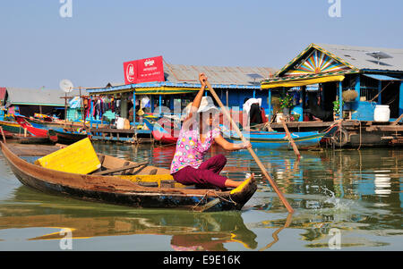 Buntes Bild der Kambodschanischen Frau Paddeln mit einem kleinen Boot durch ein schwimmendes Dorf am Tonle Sap See, Kambodscha, Südostasien Stockfoto