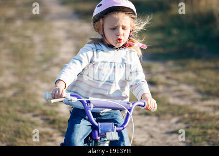 Kleine lustige Kind Reiten Fahrrad mit Stützrädern. Stockfoto