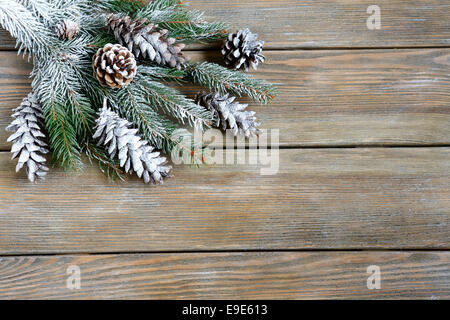 Xmas Tanne Zweig mit Zapfen auf Brettern, Weihnachten Hintergrund Stockfoto