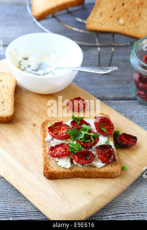 Bruschetta mit sonnengetrockneten Tomaten auf ein Schneidebrett, italienische Küche Stockfoto