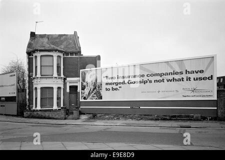 isolierte verurteiltes Haus eingeklemmt zwischen zwei großen Plakatwänden in den 1990er Jahren Portsmouth uk Stockfoto