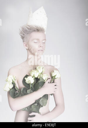 Kunstfertigkeit. Trendige jungen Mann in Papierkrone mit Blumen Stockfoto