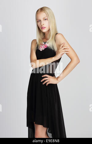 Anspruchsvolle Dame im schwarzen seidigen Abendkleid elegant posiert Stockfoto