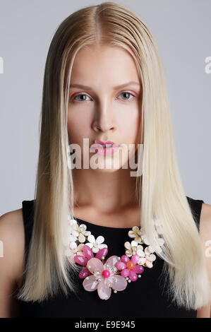 Ornamentik. Pfiffigen blonde Frau mit Blumen Halskette Stockfoto