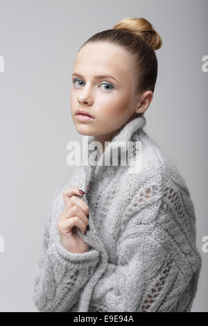 Portrait von junge hübsche Frau in gestrickter Wolle grau Jersey Stockfoto