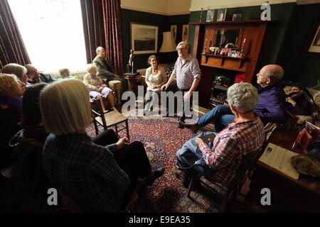 Swansea, Großbritannien. Samstag, 25. Oktober 2014 im Bild: Walisischer Schriftsteller, Schauspieler, Sänger und Musiker Boyd Clark mit Kirsten Jones mit dem Publikum in der Stube von Dylan Thomas Geburtshaus.  Re: Dylan Thomas Geburtstag Jahrhundertfeiern an seinem Geburtsort, 5 Cwmdonkin Drive, Swansea, Südwales. Bildnachweis: D Legakis/Alamy Live-Nachrichten Stockfoto