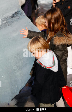 Kopenhagen, Dänemark. 26. Oktober 2014. Kinder spüren die Magie des Inlandeises. Die Kunst im öffentlichen Raum Stück Ice Watch in der City Hall von dänisch-isländischen Künstlers Olafur Eliasson und Geologe Minik Rosing. 100 Tonnen von Inlandeis von Nuup Kangerlua Fjord, Nuuk nach Kopenhagen in Kühlcontainern transportiert. Das Schmelzen von zwölf große Eisblöcke gebildet, wie eine Uhr dient als eine Klimaerwärmung Weckruf: 100 Tonnen von Inlandeis schmelzen jedes 100. einer Sekunde. Stockfoto