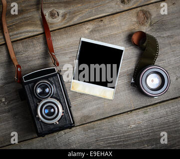 Vintage-Kamera mit objektiven und leere altes Foto auf Holz Hintergrund Stockfoto