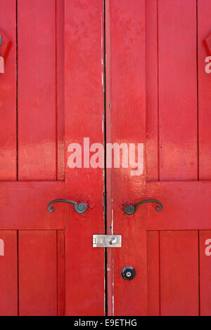 Teil der alten Holztür rot mit Metallgriff Stockfoto