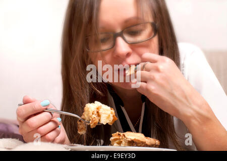 Junge Frau essen Kuchen Stockfoto