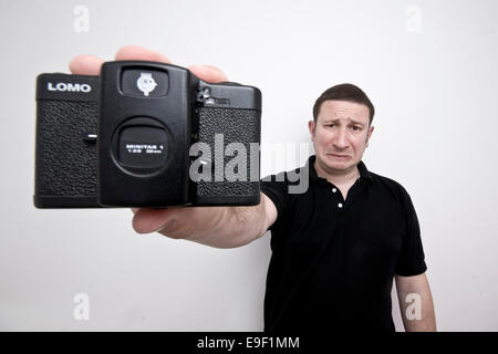 ein Mann hält einen alten Vintage Lomo-Film-Kamera und hat einen traurigen Ausdruck Stockfoto